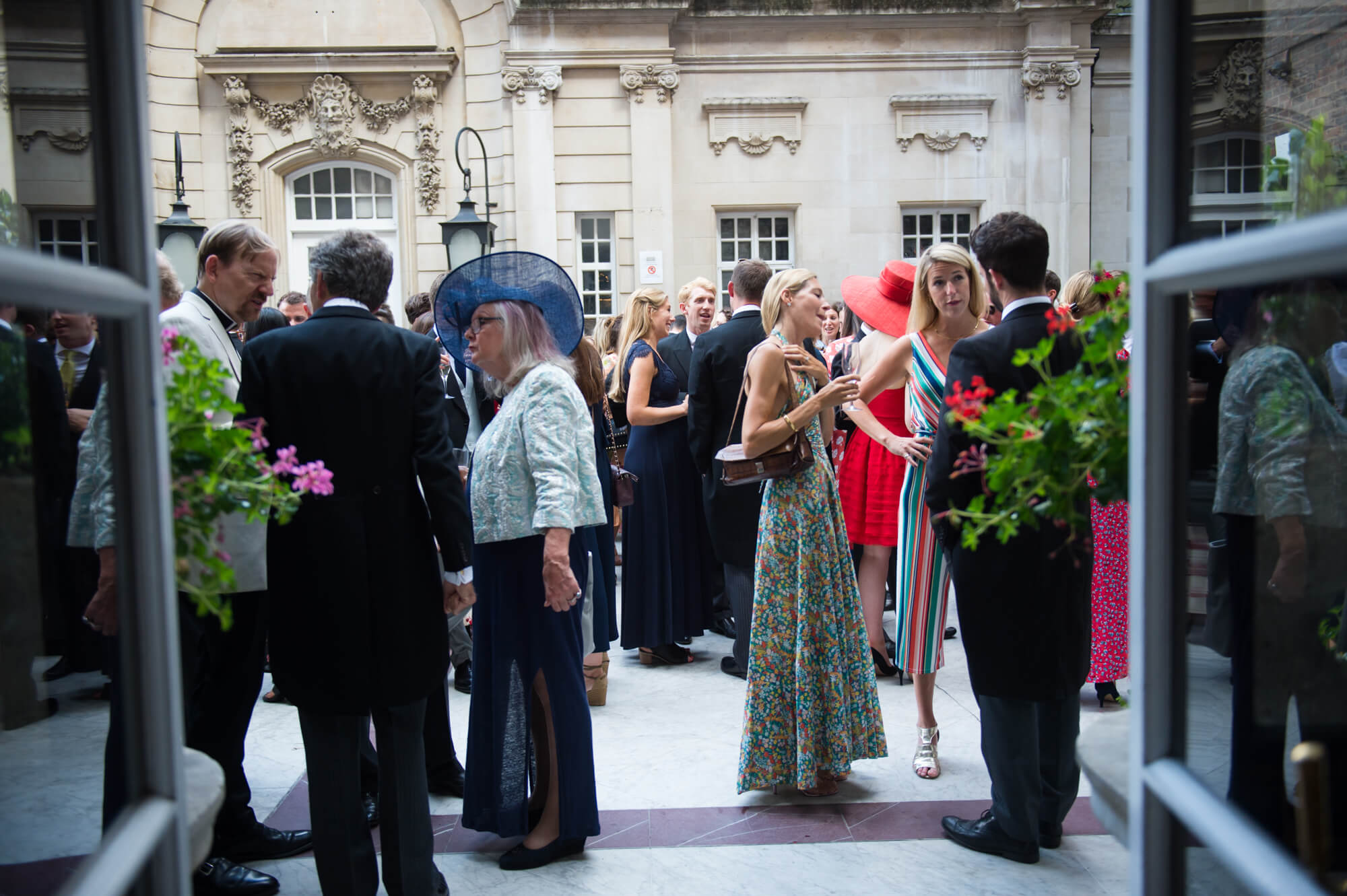 Guests enjoying the wedding celebrations in the courtyard of Dartmouth house